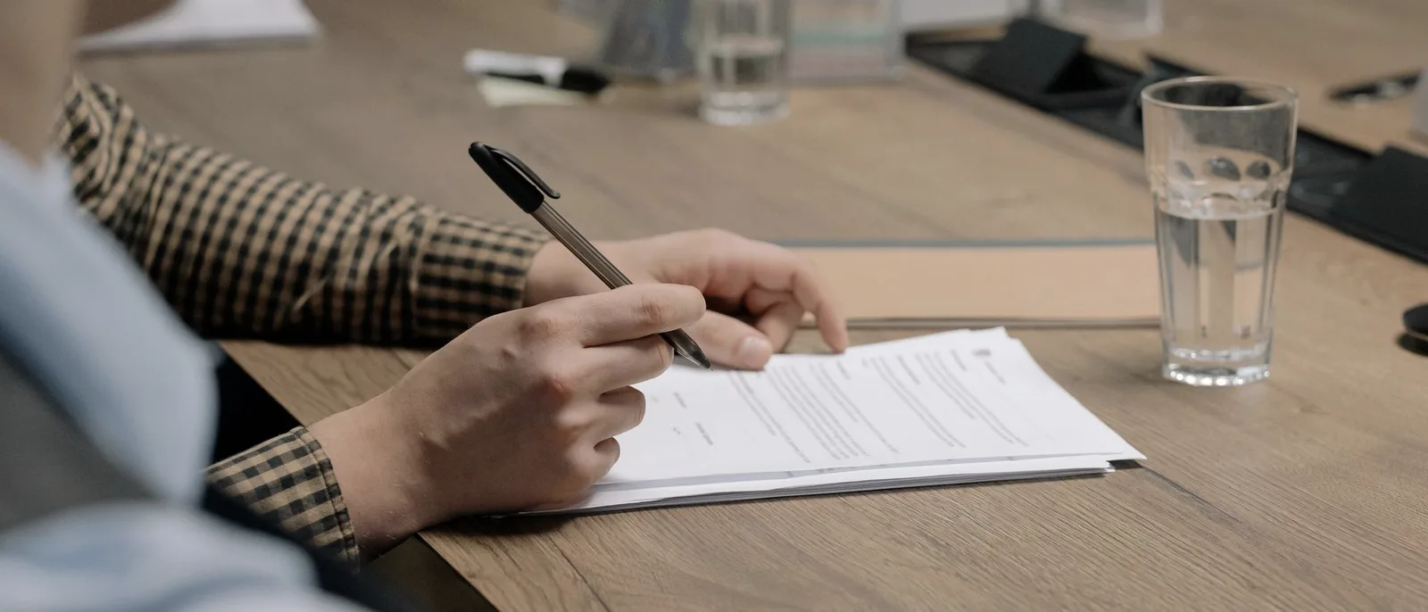 Hands writing on a printed document at a desk